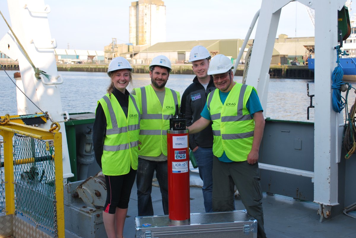People posing for a photo around an oceanographic instrument