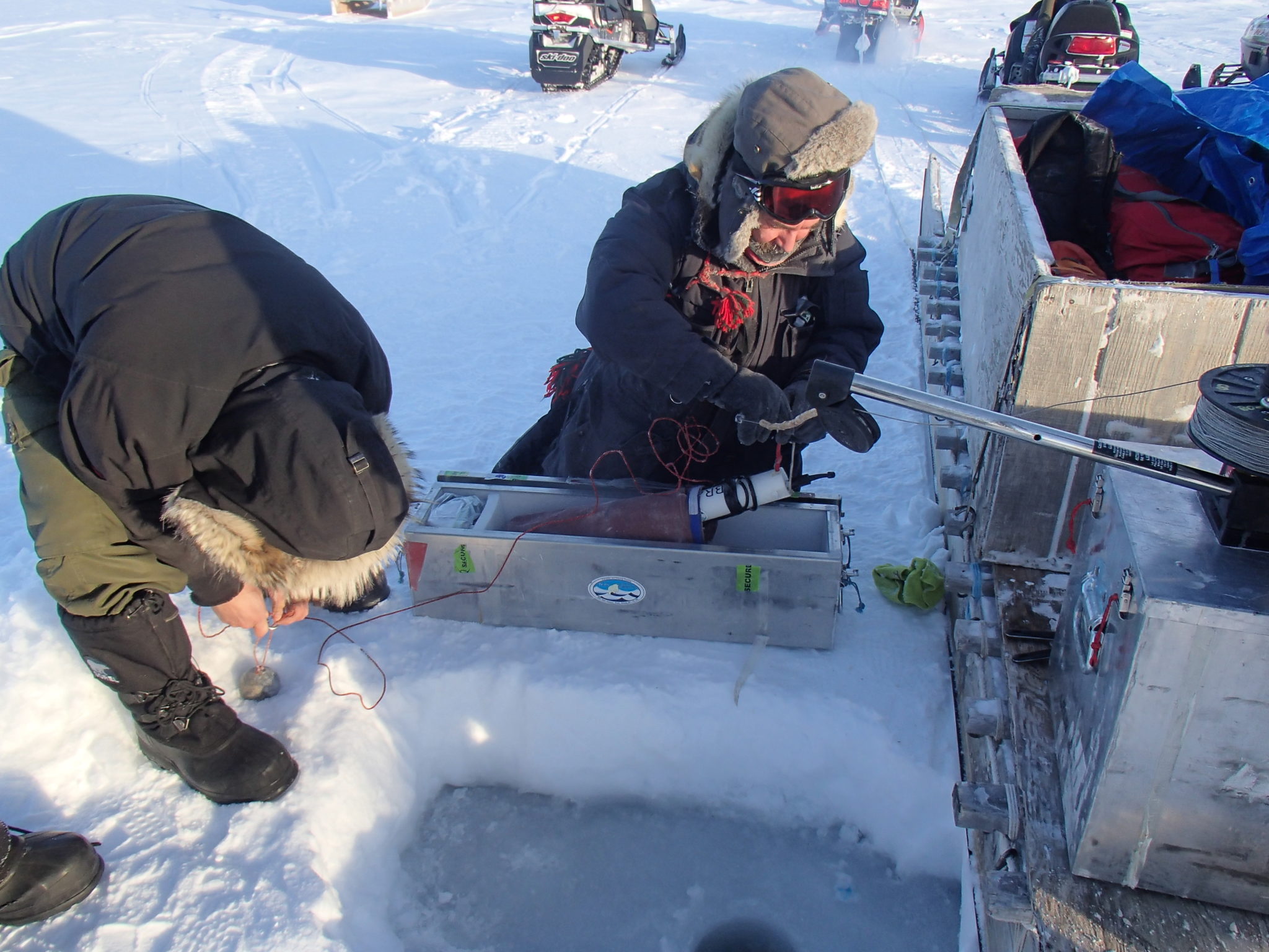 CANADIAN RANGERS TIE AN RBRCONCERTO CTD TO A DOWNRIGGER LINE, TAKING THE CTD OUT OF ITS SACK AND ALUMINUM BOX WHERE CHEMICAL HAND WARMERS KEEP IT WARM.